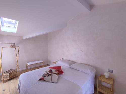 Un dormitorio blanco con una cama blanca con flores. en IseoLakeRental - La Filandina, en Riva di Solto