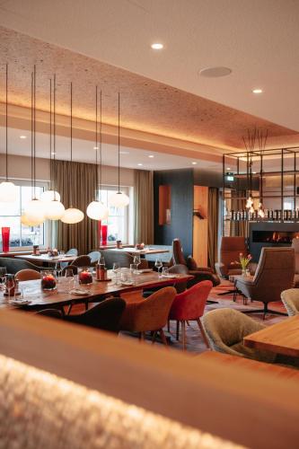 a restaurant with tables and chairs and lights at Hotel Elfbuchen in Kassel