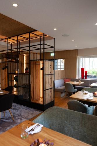 a restaurant with wooden tables and chairs and a room with tables at Hotel Elfbuchen in Kassel