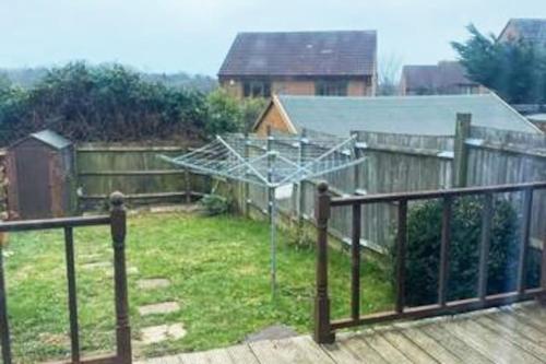 uma vista para um pátio com uma cerca em Home from Home sleeps seven em Hastings