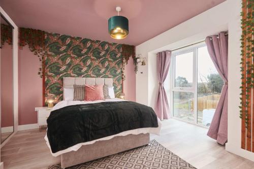 a bedroom with a bed with a green and pink wall at Homebird Property - The Willows in Leeds