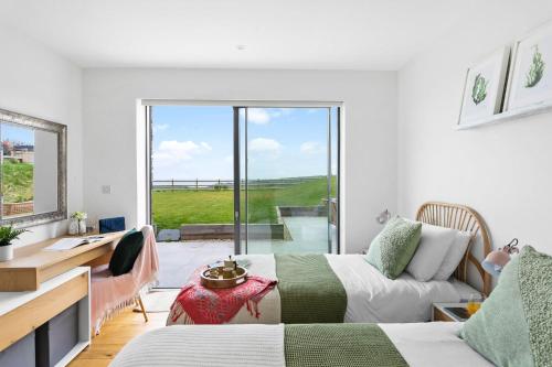 sypialnia z 2 łóżkami, biurkiem i oknem w obiekcie Higher Poole, Slapton w mieście Slapton