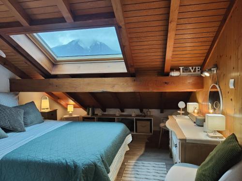 une chambre avec un lit, un bureau et une fenêtre dans l'établissement Charmant Duplex T3 avec Balcon - Halle Olympique, à Albertville