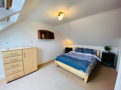 a bedroom with a bed and a dresser in it at Family Relax in the Seaside Town with Parking in Hastings
