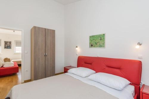 1 cama con cabecero rojo en un dormitorio en Tereza, city central modern apartment, en Novalja