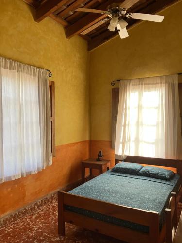 - une chambre avec un lit et un ventilateur de plafond dans l'établissement Hostel Iguana Azul, à Copan Ruinas