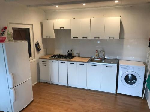 a kitchen with white cabinets and a washing machine at Domek letniskowy nad jeziorem mazury Wilimy 127 in Wilimy