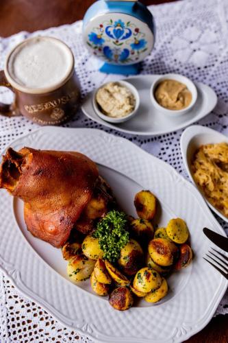 a plate of food with a chicken and potatoes on a table at Nordowi Dwór in Celbowo