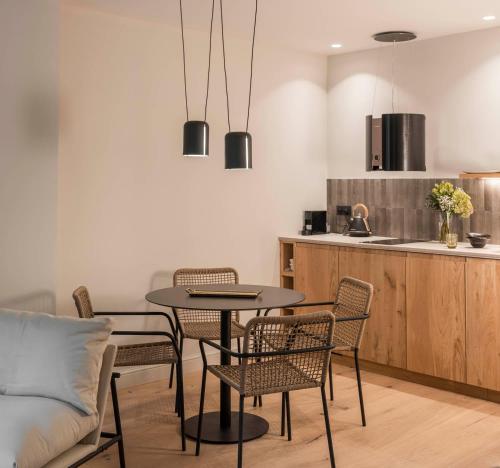 a dining room with a table and chairs and a kitchen at Can Verí Suites in Sóller