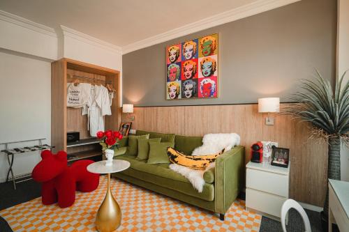 a living room with a green couch and a red stuffed animal at Macau Hotel S - Formerly - Macau Hotel Sun Sun in Macau