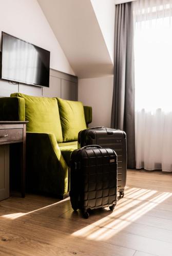a living room with a couch and two pieces of luggage at Nordowi Dwór in Celbowo