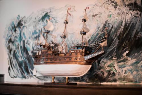 a model ship on a table in front of a mural at Nordowi Dwór in Celbowo