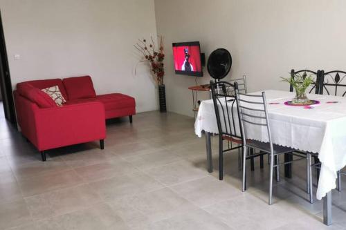 Una sala de estar con una mesa y una silla roja. en Cosy apartment on the 1st floor, en Curepipe
