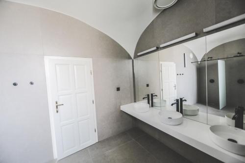 a bathroom with two sinks and two mirrors at Ruttner Ház in Veszprém