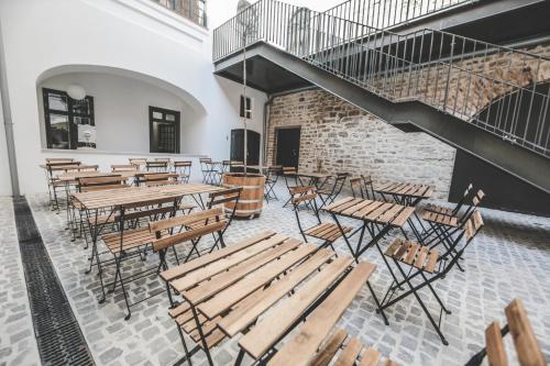 un restaurante vacío con mesas y sillas de madera en Ruttner Ház en Veszprém