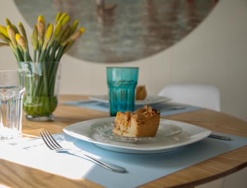 a plate with a piece of cake on a table at ThuizInOuddorp Parel no 30 & Oester no 29 Verkoeling aan Zee in Ouddorp