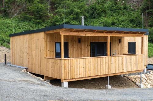 a small wooden building with a black roof at Seehäuser Dobra 