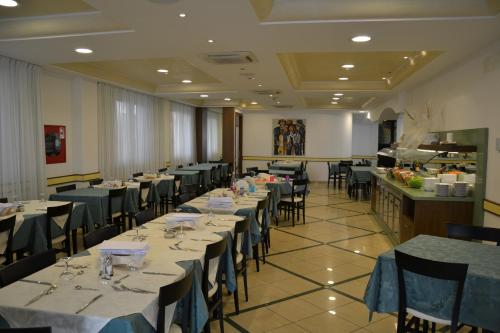 uma sala de jantar com mesas e cadeiras com toalhas de mesa azuis em Hotel Ariston em Misano Adriatico