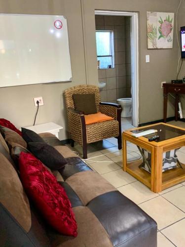 a living room with a couch and a table at East Cottage in Boksburg