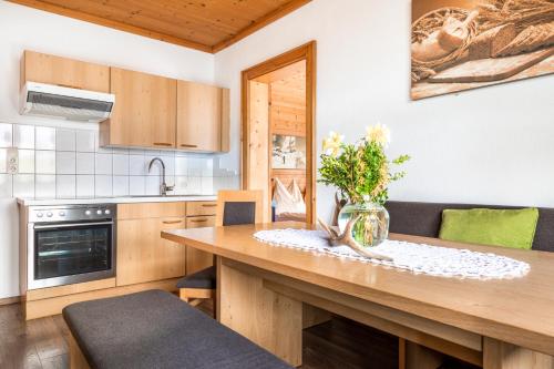 a kitchen with a wooden table with a vase of flowers on it at Hallmoosgut in Sankt Johann im Pongau