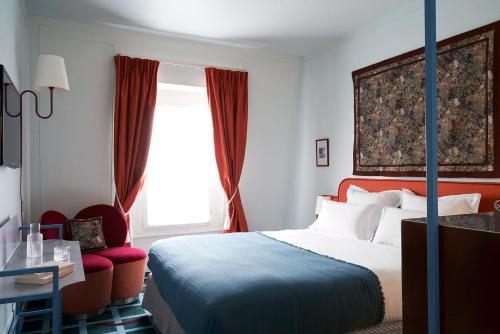 a hotel room with a bed and a window at Hôtel Beauregard in Paris