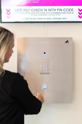 a woman is looking at a lightswitch on a wall at HOTEL MARIA in Gramatneusiedl