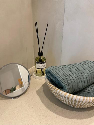 a mirror sitting next to a basket with a blanket at Studio Delfien in Oostduinkerke