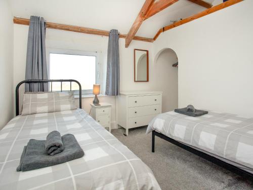 sypialnia z 2 łóżkami i oknem w obiekcie Mews Cottage w mieście Tintagel