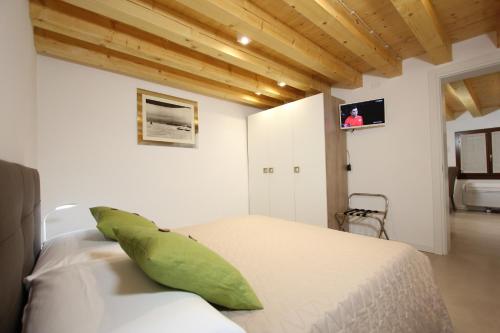 um quarto com uma cama branca e uma almofada verde em Ca' Puccetti em Veneza