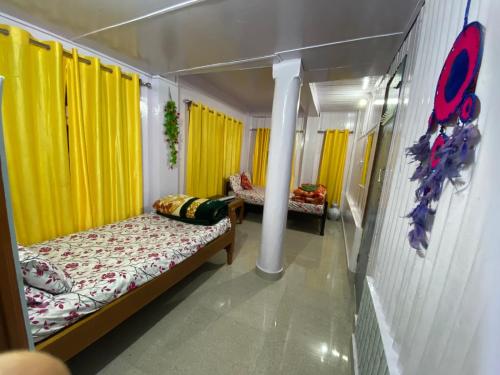 1 dormitorio con 2 camas y cortinas amarillas en Kalimpong View Homestay, en Kalimpong