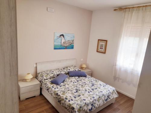 a bedroom with a bed and a bird picture on the wall at La Casera in Lido di Dante