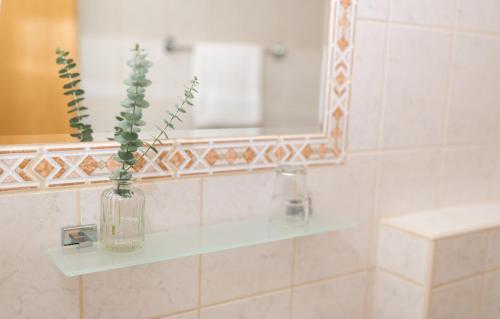 a bathroom with a glass vase with a plant in it at HOTEL MARIA in Gramatneusiedl