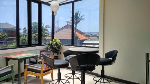 a room with chairs and a table and a window at MAXI HOTEL KEDONGANAN in Kuta