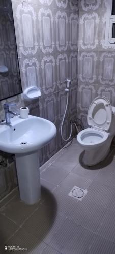 a bathroom with a white toilet and a sink at Wummies place in Abu Dhabi
