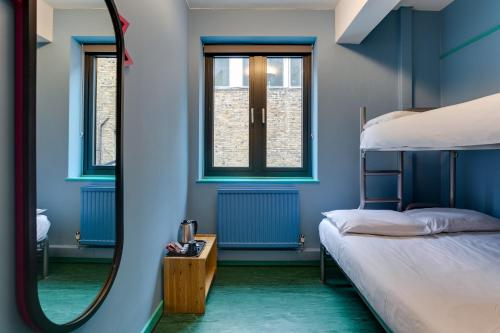 Schlafzimmer mit blauen Wänden und einem Bett mit Spiegel in der Unterkunft Clink261 Hostel in London