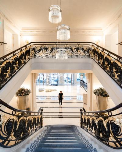 a man walking down a staircase in a building at The Peninsula Paris in Paris
