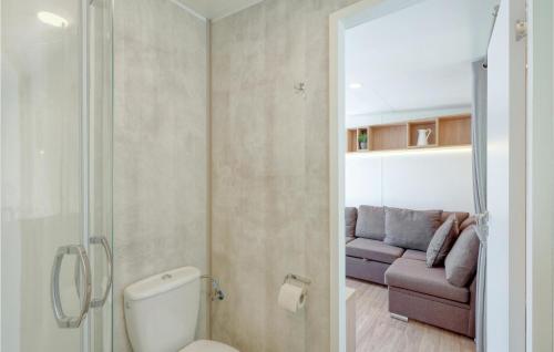 a bathroom with a toilet and a couch in a room at Tiny Haus 67 Am Brombachsee in Pleinfeld