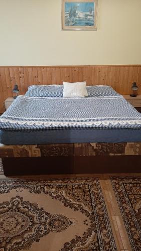 a bedroom with a bed with a blue comforter at Guest House Vila Frýdštejn in Frýdštejn
