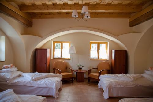 a hotel room with two beds and two chairs at Török Vendégház in Jobaháza