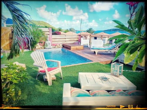 a backyard with a pool with a chair and a table at LA CABANE D'artiste in Cul de Sac