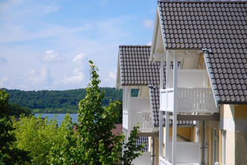 a building with white balconies and a view of a lake at Wohnpark Stadt Hamburg - Apt. 47 in Binz