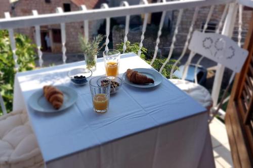 un tavolo blu con piatti di cibo e bicchieri di succo d'arancia di Studio apartman Tomi - seaview a Vis