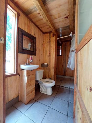 baño de madera con aseo y lavamanos en Cabaña en el Bosque de San José del Pacífico en El Pacífico