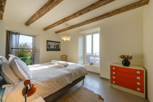 - une chambre avec un lit, une commode rouge et des fenêtres dans l'établissement Charmante maison avec Vue LAC et Montagnes - PISCINE privative - LLA Selections by Location lac Annecy, à Saint-Jorioz