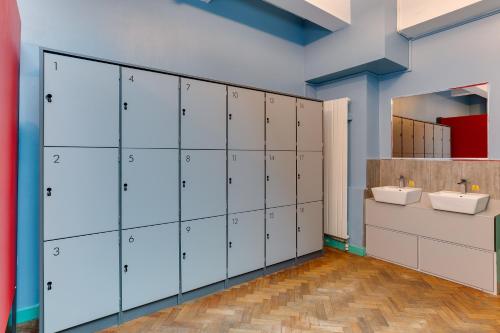 a bathroom with white lockers and two sinks at Clink261 Hostel in London