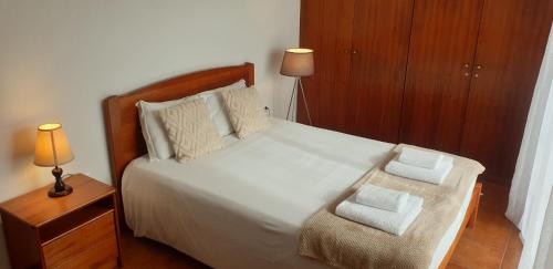 a bedroom with a large white bed with a chair at Casa da Conceição - Bay View Spot in Funchal