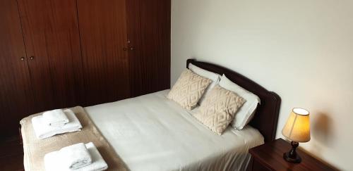 a bed with white sheets and pillows and a lamp at Casa da Conceição - Bay View Spot in Funchal