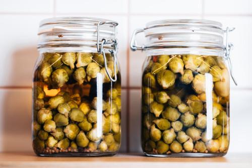 two jars filled with pickles on a counter at Hotel Gilbert in Vienna