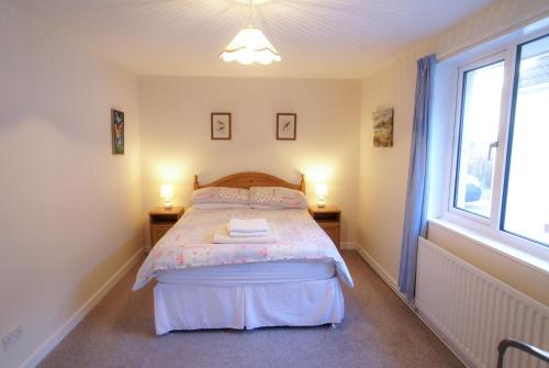 um quarto com uma cama com duas mesas e uma janela em Millfield em Rockcliffe