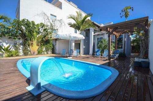 una piscina con un tobogán en el medio de una casa en Linda casa com piscina e 4 suites no mariscal a 100 metros da praia, en Bombinhas